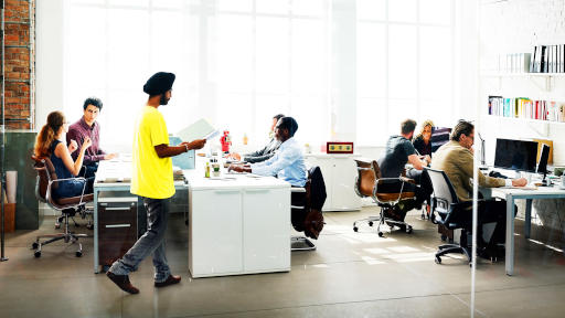 A diverse group of people are working together in an open office.
